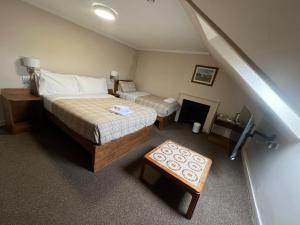 a bedroom with two beds and a fireplace and a staircase at Burntisland House in Burntisland