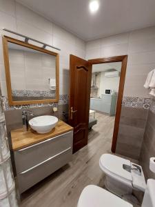 a bathroom with a sink and a toilet and a mirror at ToledoAloja - Estudio en Toledo in Toledo +156 photos