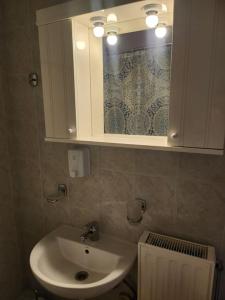 een badkamer met een wastafel en een kast met een spiegel bij 'Elia gytheio in Mavrovoúnion