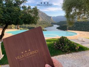 a person holding a sign with a view of a river at Hotel Villa Cedrino in Dorgali