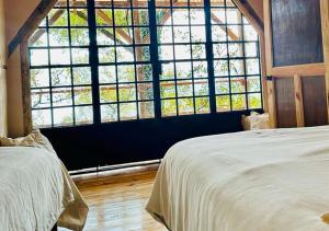 a bedroom with two beds and a large window at Earth Lodge in Antigua Guatemala