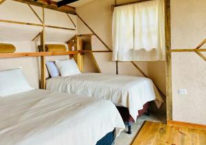 a room with two beds and a window at Earth Lodge in Antigua Guatemala