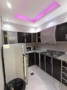 a kitchen with purple lights on the ceiling at سيلين الزهراء in Jeddah