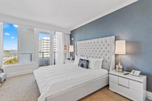 a bedroom with a large white bed and two windows at Luxury King apartment with Bay View at Miami Beach in Miami Beach