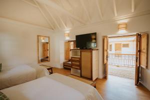 a hotel room with two beds and a television at Hotel La Corada in Villa de Leyva +168 photos