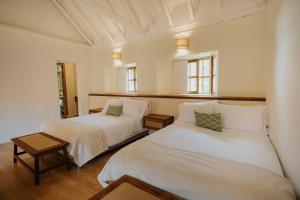 a bedroom with two beds and a mirror at Hotel La Corada in Villa de Leyva
