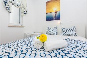 - une chambre blanche avec un lit bleu et blanc dans l'établissement Villa Miri Lily, à Privlaka