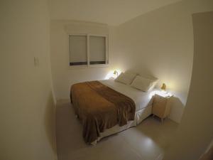 um quarto com uma cama e uma janela com 2 candeeiros em Fullano B&B no Rio de Janeiro