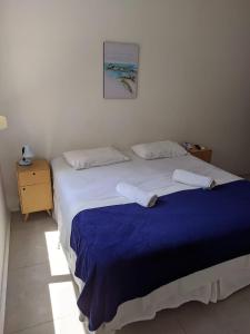 uma cama com duas almofadas brancas e um cobertor azul em Fullano B&B no Rio de Janeiro