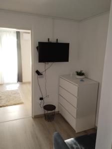een woonkamer met een flatscreen-tv aan de muur bij Apartment Happy 2 in Pakoštane