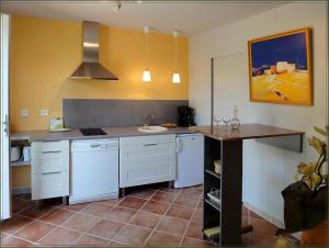 Saint-AndiolにあるLa Gourmandineの白い家電製品とテーブル付きのキッチン