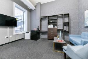 Temple Place Suites 2+3 في بوسطن: غرفة معيشة مع أريكة زرقاء وتلفزيون