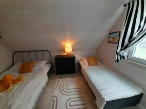 - 2 lits dans une chambre avec une lampe et une fenêtre dans l'établissement Babki z Piasku, à Dziwnów