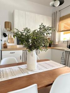 a dining room table with a vase with a plant on it at Anerada Cottages in Apsiou