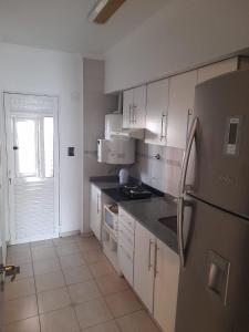 a kitchen with white cabinets and a stainless steel refrigerator at Departamento Boulevard Centro in Santa Fe