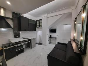 a living room with a black couch and a kitchen at Studio Apartment Santa Caterina in Bologna