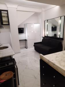 a living room with a black couch and a kitchen at Studio Apartment Santa Caterina in Bologna