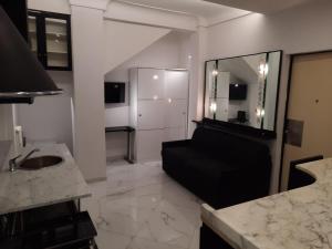 a living room with a black couch and a kitchen at Studio Apartment Santa Caterina in Bologna