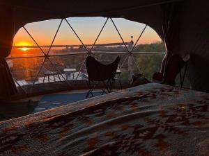 a bed in a tent with a view of the sunset at Sunset Dome - Outdoor Shower/Composting Toilet in Valley Center