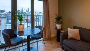 un soggiorno con tavolo, sedie e finestra di Pacific Residences - Studio ad Anversa