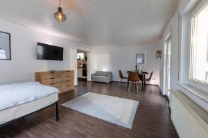 a bedroom with a bed and a dining room with a table at Pitlane-Apartment in Herresbach