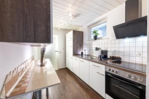 uma cozinha com armários brancos e uma bancada em Pitlane-Apartment em Herresbach