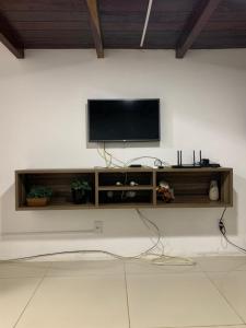 telewizor z płaskim ekranem siedzący na ścianie w obiekcie A12 Pé na Areia w mieście Marechal Deodoro