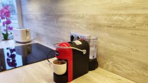 a red coffee machine sitting on top of a table at Barona apartement in Jelgava