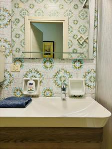 La salle de bains est pourvue d'un lavabo blanc et d'un miroir. dans l'établissement GRADISSIMO, à Grado-Pineta