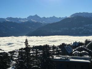 a view of a snow covered mountain range with mountains at Sorecrans in Crans-Montana