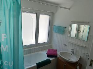 a bathroom with a tub and a sink and a window at Sorecrans in Crans-Montana