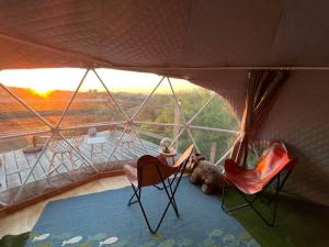 a room with two chairs and a teddy bear in a tent at Sunset Dome - Outdoor Shower/Composting Toilet in Valley Center