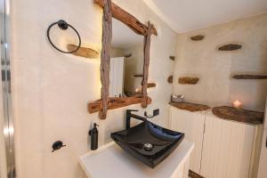 baño con lavabo negro y espejo en M&K kelè, en Kardhianí