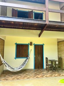 a house with a hammock on the outside of it at Ayo Bistrô Pousada in Marau