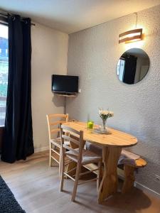 a dining room table with chairs and a mirror at Charmant studio Risoul 1850 in Risoul