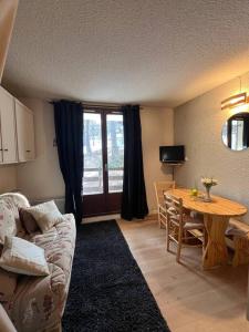 a living room with a couch and a table at Charmant studio Risoul 1850 in Risoul +2 photos
