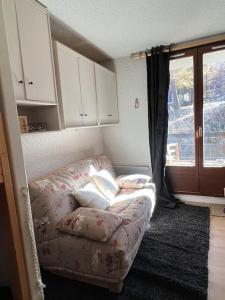 a living room with a couch and a window at Charmant studio Risoul 1850 in Risoul