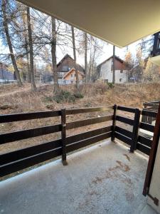 a wooden fence with a view of a field at Charmant studio Risoul 1850 in Risoul
