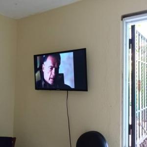 a flat screen tv hanging on a wall at apartaestudio santo domingo a 40 minutos playa. in Los Tres Brazos