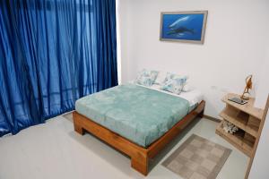 1 dormitorio con 1 cama con cortinas azules en Modernas Habitaciones en Puerto Ayora