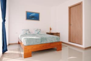 a bedroom with a bed and a table and a door at Modernas Habitaciones in Puerto Ayora