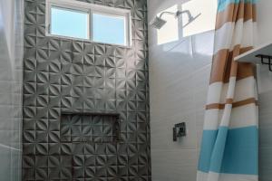 y baño con ducha y ventana. en Modernas Habitaciones en Puerto Ayora