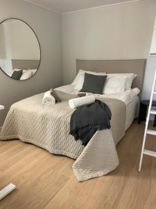 Schlafzimmer mit einem Bett und einem großen Spiegel in der Unterkunft Upea huoneisto Kakolassa kivalla näkymällä meren suuntaan in Turku