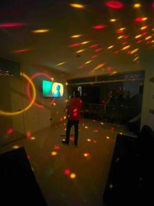 a person standing on a dance floor in a room at Aura Chincha® Casa con Piscina, Karaoke y más! in Chumbiaula