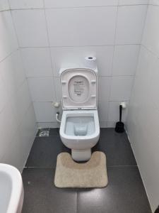 uma casa de banho com WC com assento para cima em AJALA Lodge em Badagry