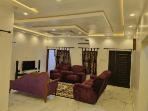 a living room with two chairs and a television at AJALA Lodge in Badagry