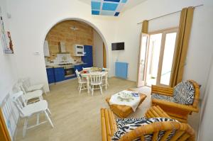 een keuken en een woonkamer met een tafel en stoelen bij CASA MONDRIAN in Tiggiano