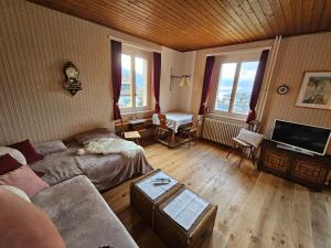 ein Wohnzimmer mit einem Sofa und einem TV in der Unterkunft La Pergola in Montreux
