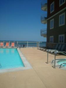 una piscina accanto a un edificio con sedie e l'oceano di Lovely 2-bedroom Suite with lots of Amenities a Traverse City
