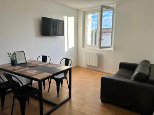 ein Wohnzimmer mit einem Tisch und einem Sofa in der Unterkunft Résidence Le Gond in Le Gond